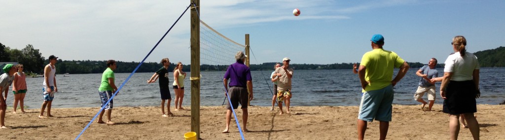A group of people playing beach volleyball